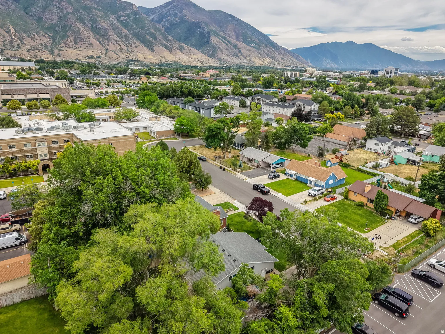 Aerial perspective showcasing a neighborhood with varied residential structures and mature trees