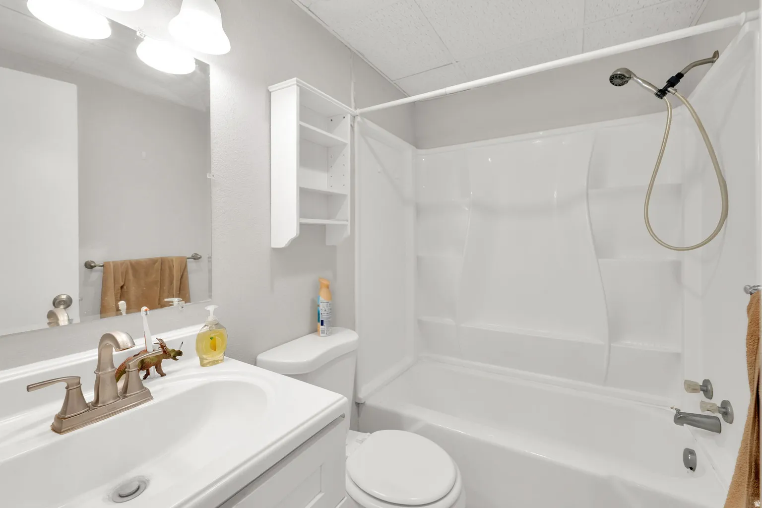 Bathroom featuring a single vanity with brushed nickel fixtures, a built-in medicine cabinet, and a white shower/tub combination with a handheld showerhead