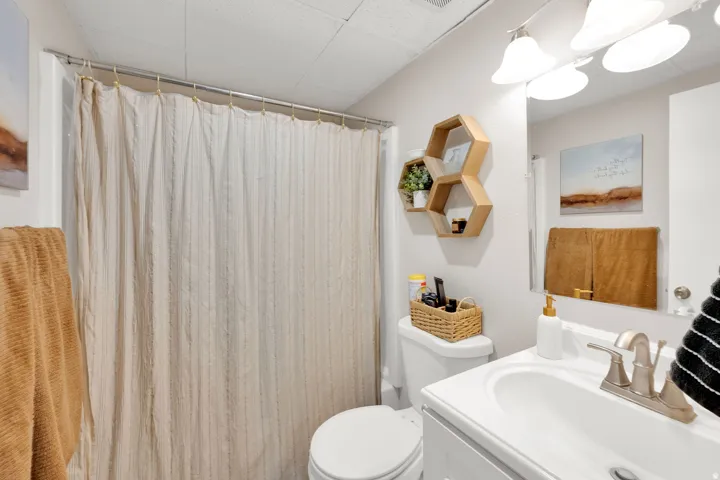 Bathroom with a white vanity and integrated sink, brushed nickel faucet, and a wall-mounted mirror