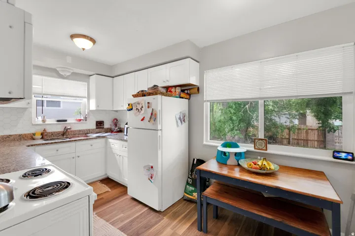 Kitchen featuring white cabinetry, a hexagonal tile backsplash, and light-toned countertops