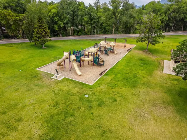 Community park featuring a large play structure with multiple slides and climbing elements set on a sand base