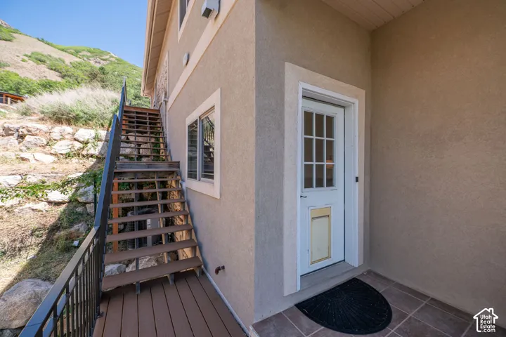 Second level outdoor entry, Stucco exterior with a multi-pane entry door, composite decking, and metal railing