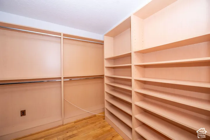 Custom walk in closet system featuring extensive shelving and dual hanging rods