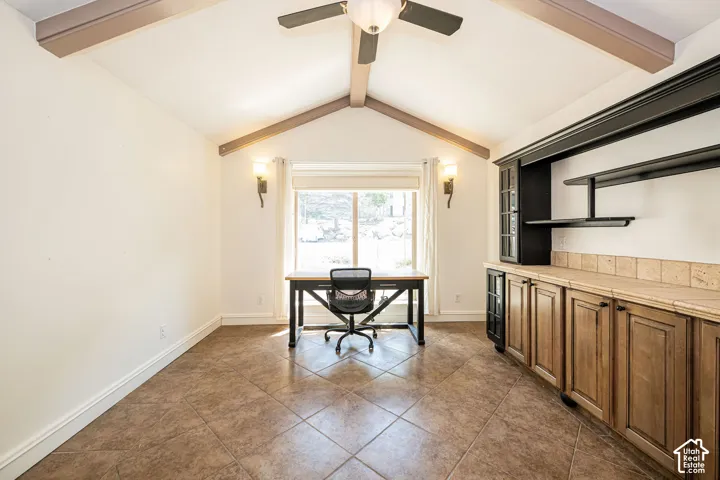 Vaulted ceiling with exposed beams and central ceiling fan