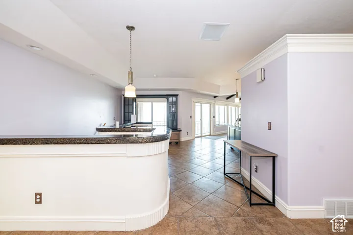 Curved bar with a dark, textured countertop and white paneling