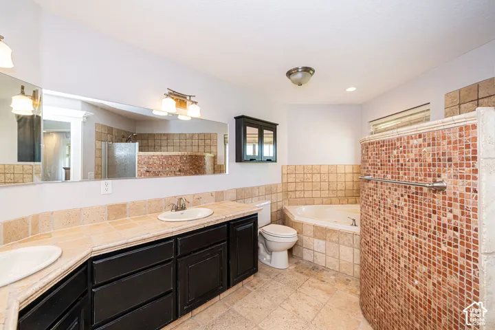 Master bathroom with dual vanity, recessed lighting, tile flooring, a corner soaking tub, and a separate walk-in shower with mosaic tile