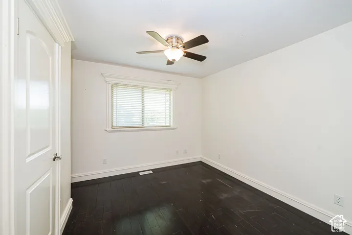 Interior room featuring dark wood-finish flooring and white walls. Bedroom includes an ensuite.