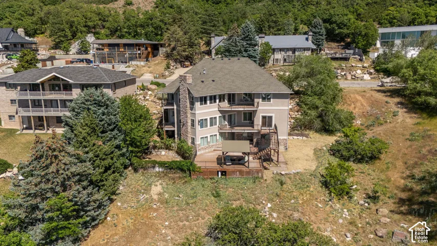 Multi-level residence featuring a dark shingle roof, neutral-toned siding, and stone accents