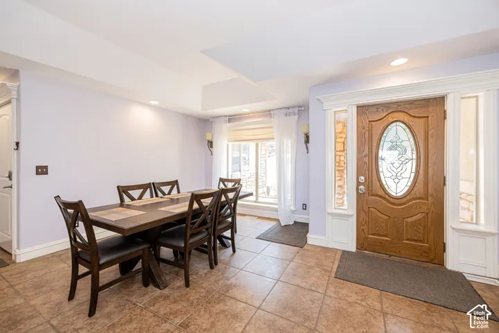 Entryway featuring a wood-panel door with oval leaded glass insert, sidelight windows, and decorative trim
