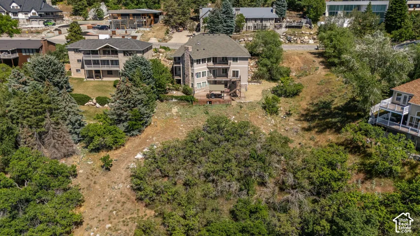 Multi-story residence featuring a gray shingle roof and a beige exterior with darker trim