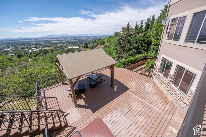 Second Level Master Bedroom patio walk out. Expansive multi-level composite deck featuring a pergola, black metal railings, and a lower-level hot tub