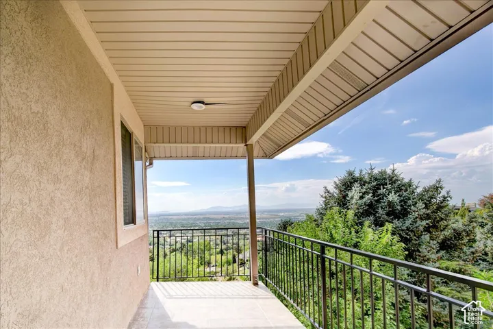 Master Bedroom covered balcony featuring tile flooring and a black metal railing. West facing sunset views.