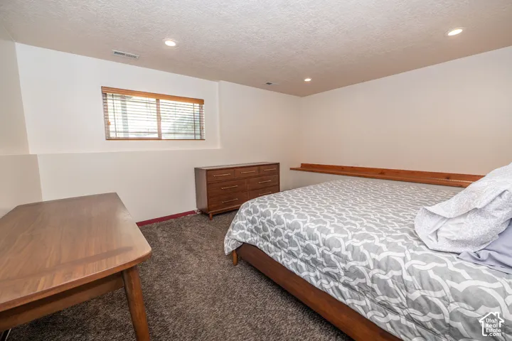 Bedroom featuring a recessed window with wood blinds, wood-finish shelving, and recessed ceiling lighting. (Set up as a bedroom in the third level. This room does not have a closet, but one could be added.)