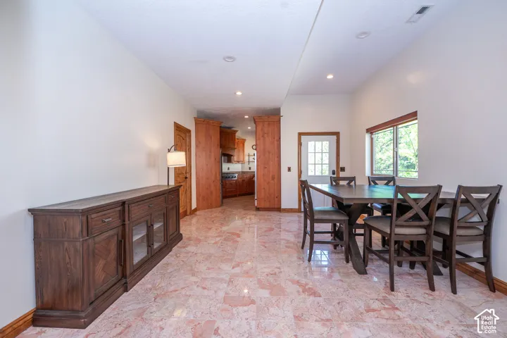 Dining area featuring extensive tile flooring, recessed lighting, and a large window