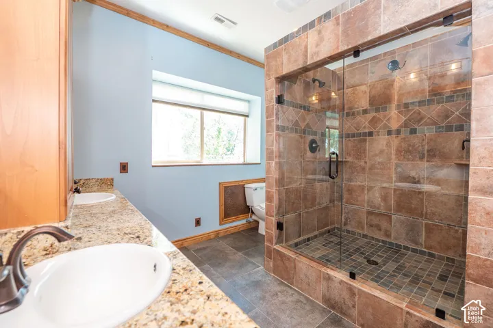 Level 2 Spacious master bathroom featuring a large walk-in shower with glass enclosure and tile surround, a dual vanity with granite countertops and undermount sinks, and a window with natural light