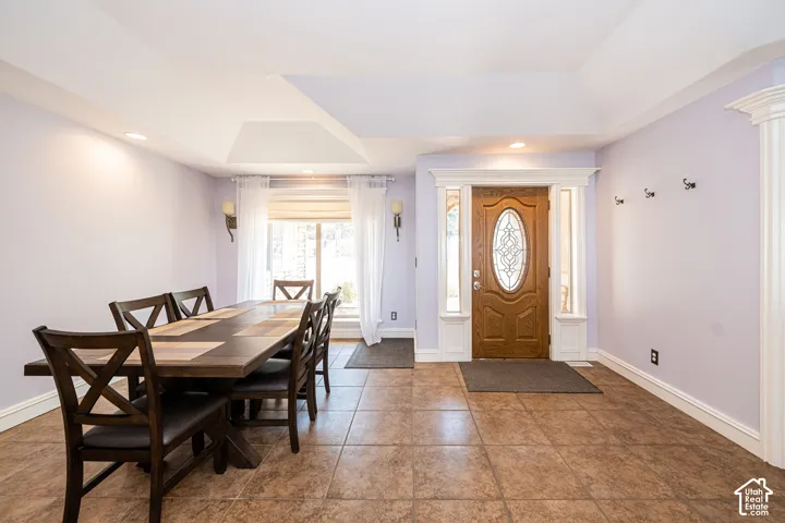 Entry foyer featuring an ornate wood front door with decorative glass, sidelights, and detailed white trim work