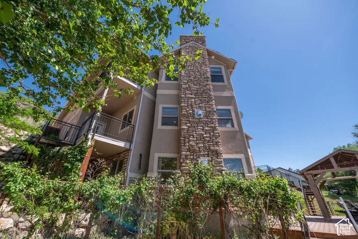 Multi-level stucco exterior with a prominent stone chimney, Fireplace on every level down, multiple decks on every level.
