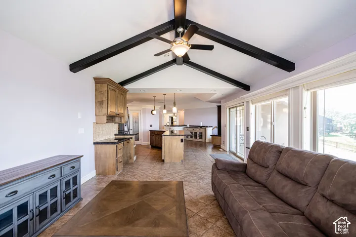 Vaulted ceiling with exposed beams and ceiling fan, tile flooring, built-in cabinetry, sliding glass doors, and recessed lighting