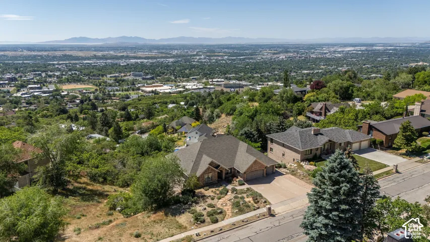 Aerial perspective showcasing a residential property with a multi-gabled roofline and attached multi-car garage