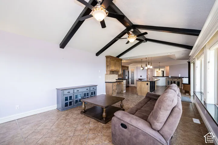 Vaulted ceiling with exposed beams and ceiling fans