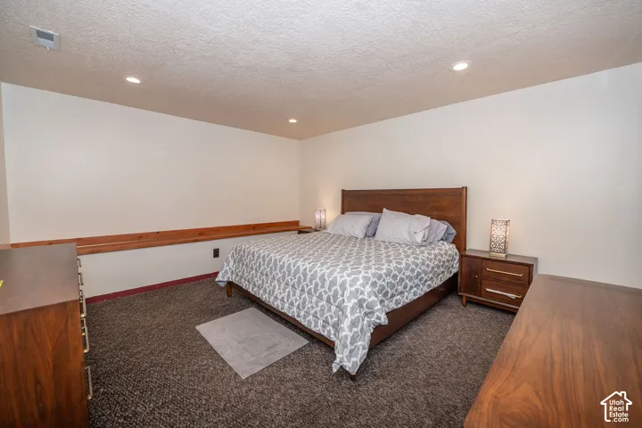 Spacious room featuring neutral painted walls, recessed lighting, and dark textured carpeting.  (Set up as a bedroom in the third level. This room does not have a closet, but one could be added.)