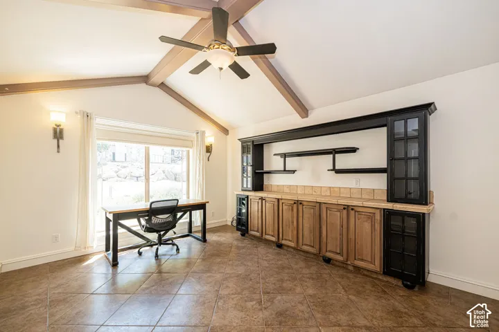 Vaulted ceiling with exposed wood beams and ceiling fan