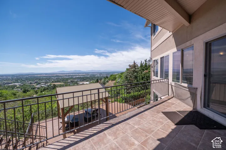 Expansive outdoor balcony featuring terracotta-toned tile flooring and dark metal railings