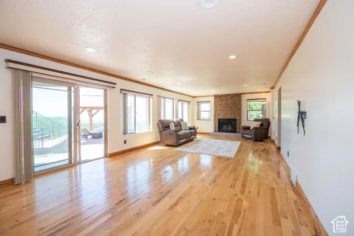 Level 3 Spacious living room featuring wood-finish flooring, recessed lighting, and a stone-clad fireplace