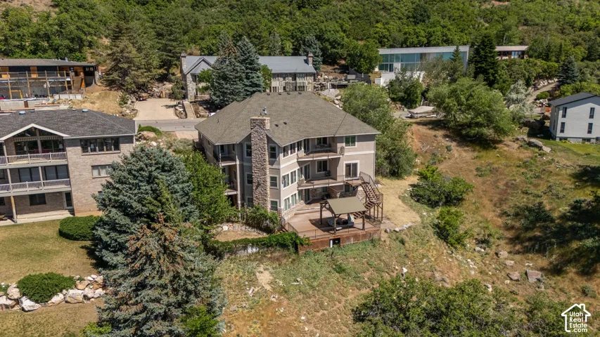 Multi-story residence featuring a prominent stone chimney and multiple outdoor decks