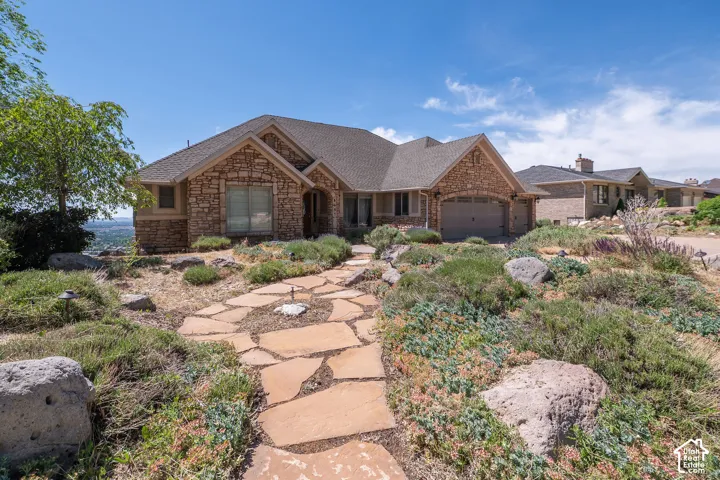 Stone-clad exterior featuring a prominent gabled roofline and an integrated three-car garage