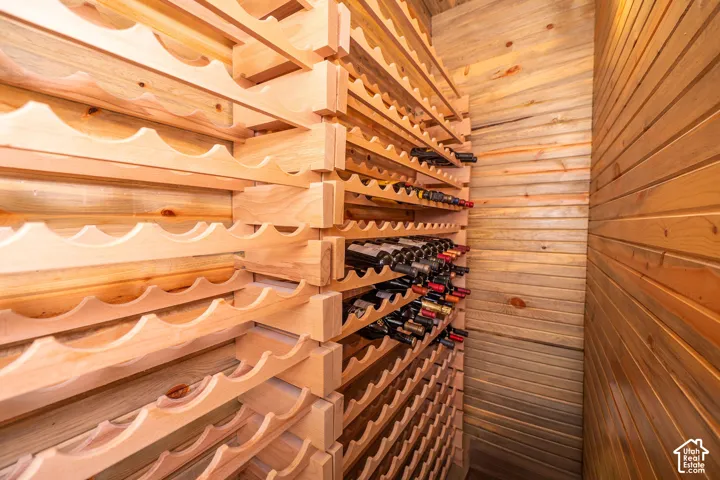 Dedicated wine cellar featuring extensive light wood racking, wood-paneled walls, and built-in bottle storage