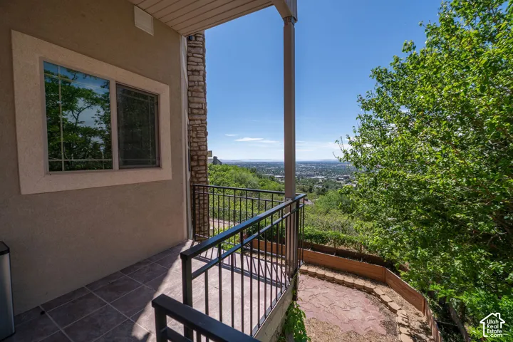 Second level outdoor entry / balcony with tile flooring and black metal railing