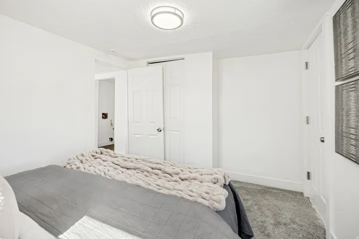 Bright bedroom with plush gray carpeting and white painted walls