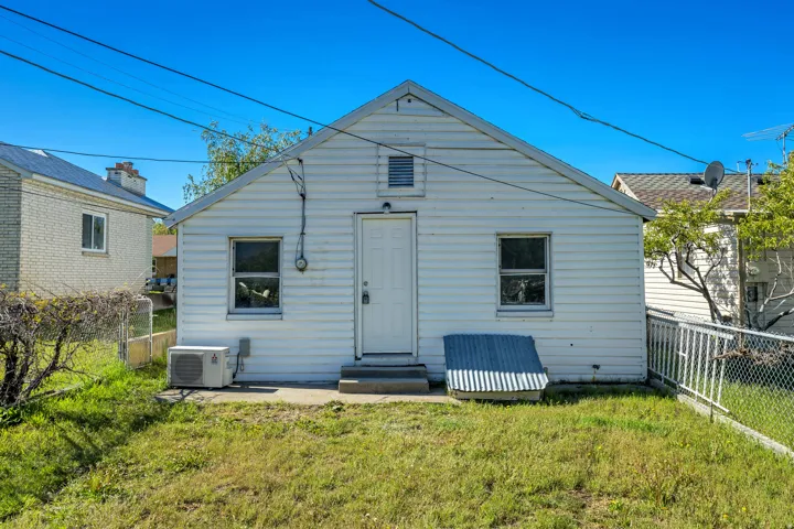 Rear exterior featuring white siding and a sloped roofline