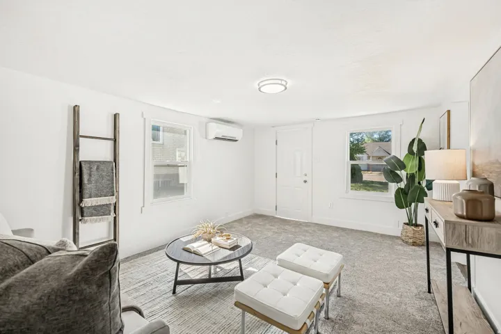 Inviting living space featuring light gray carpeting, white walls, and bright white trim