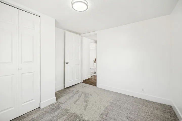 Room featuring light gray patterned carpeting, white walls, and bright white trim