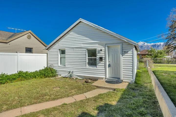 White siding exterior with a pitched roof and a front entry door