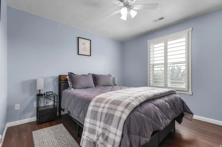 Bedroom featuring wood-finish flooring, light blue walls, and white trim