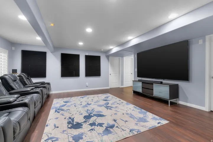 Dedicated media room featuring recessed lighting, rich wood-finish flooring, and light blue walls