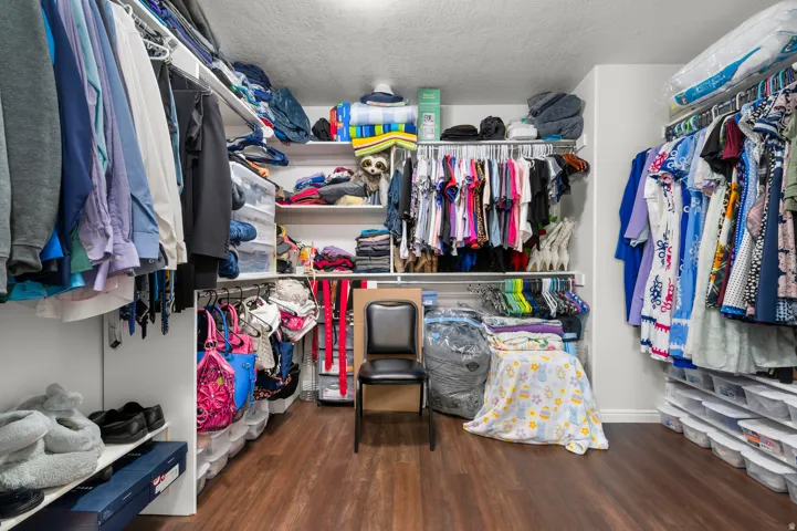 Spacious walk-in closet featuring extensive built-in shelving and hanging rods