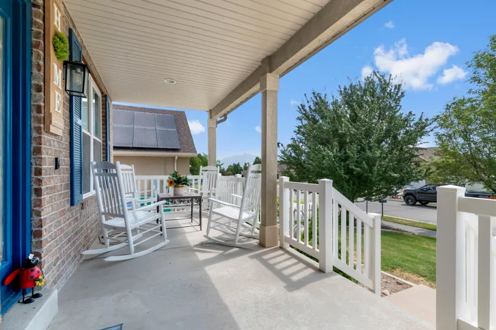 Inviting covered porch with a concrete surface and white railings