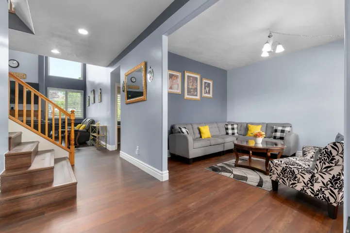 Wood-finish flooring throughout, featuring a staircase with wood balusters and a prominent newel post