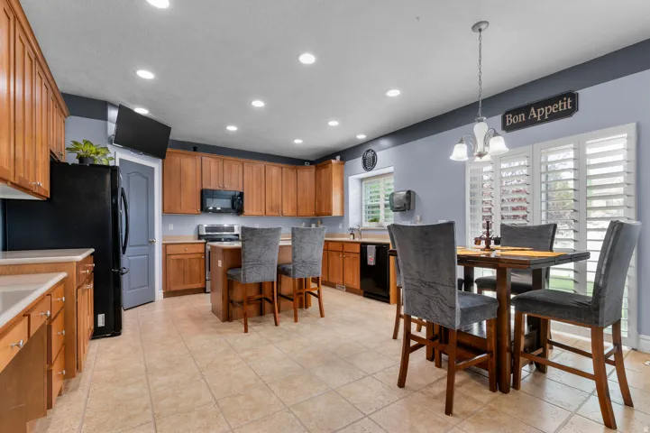 Spacious kitchen featuring light wood cabinetry, recessed lighting, and a center island with bar seating