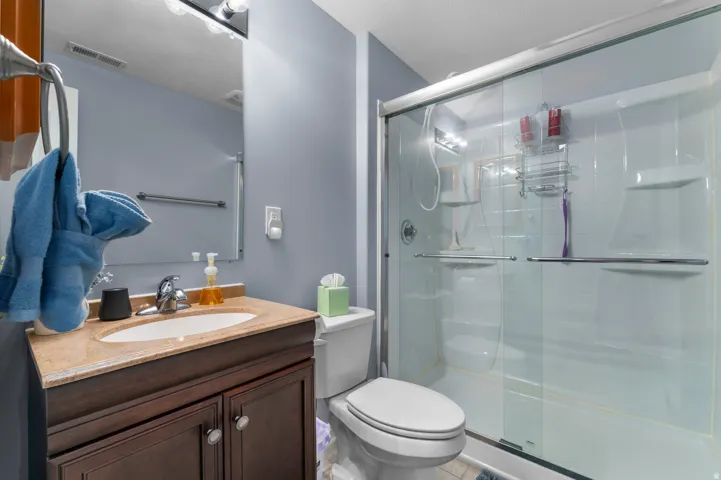 Bathroom featuring a dark wood-finish vanity with a light-colored countertop and an integrated sink