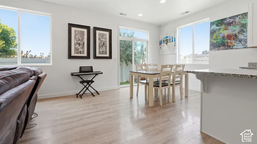 Open-concept dining space with sliding glass door access to the backyard, granite countertops, and a bright, airy layout perfect for entertaining.