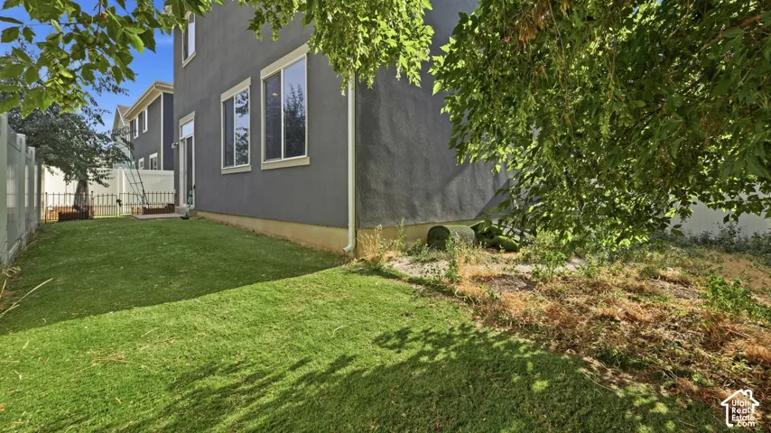 Expansive artificial  turf area alongside a stucco exterior with multiple windows and a sliding glass door