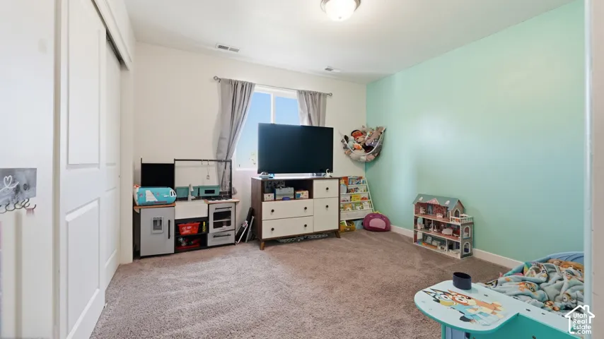 Spacious bedroom with an accent wall, closet, and window offering natural light.