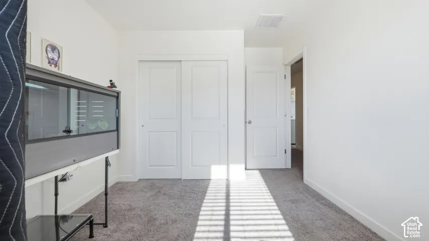 Neutral-toned carpeting extends throughout this room, complemented by white walls and trim