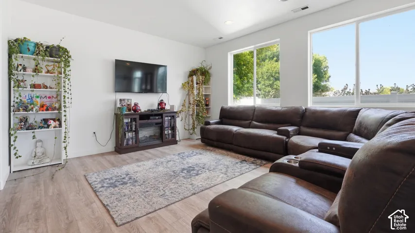 Spacious living area featuring high vaulted ceilings, wood-finish flooring, and large windows
