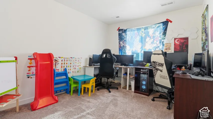 Upstairs bedroom with neutral carpet, offering flexible space for a bedroom, office, or playroom.